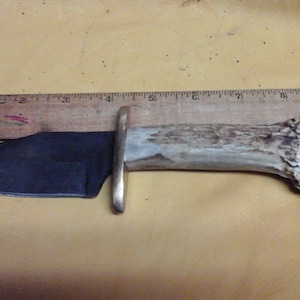 Item # 51. Damascus knife. 4 1/2 inch blade. Antler handle. Brass guard. Embossed gator sheath.