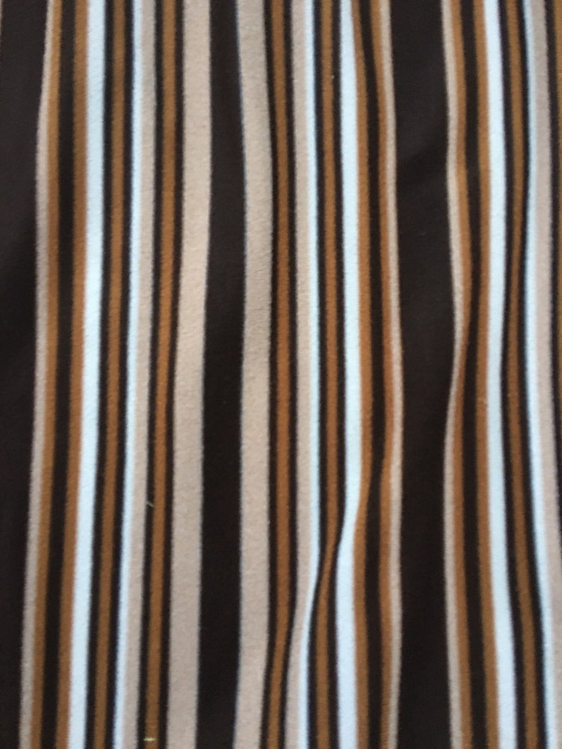 May include: A fabric with vertical stripes in brown, beige, white, and black.