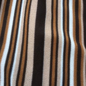 May include: Brown, beige and white striped fabric with a vertical pattern.