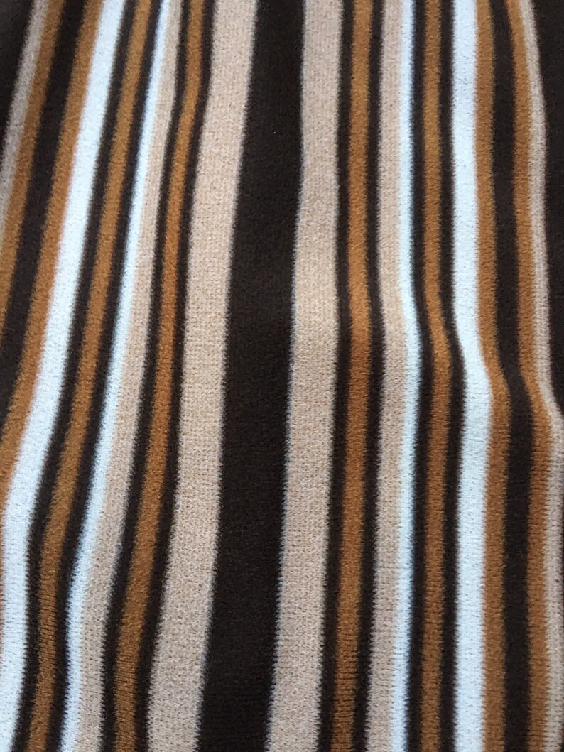 May include: Brown, beige and white striped fabric with a vertical pattern.