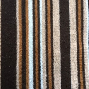May include: Brown, beige and white striped fabric with a vertical pattern.