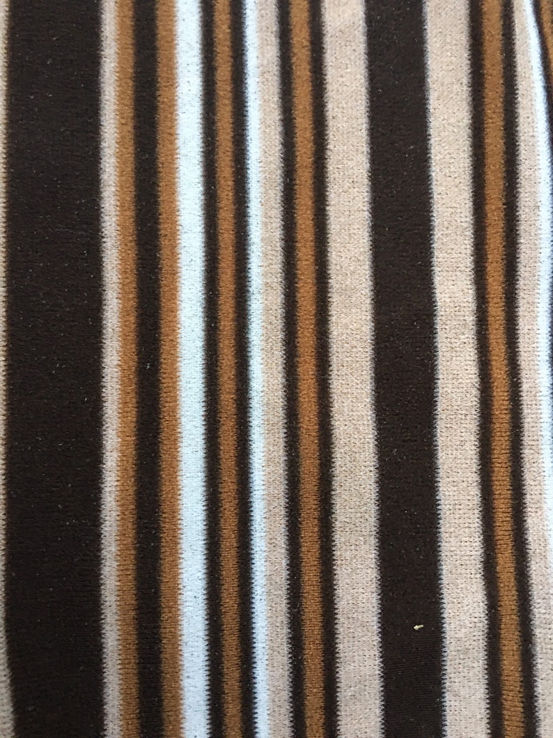 May include: Brown, beige and white striped fabric with a vertical pattern.