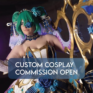 Può includere: Una persona in un costume cosplay personalizzato con capelli verdi, una benda sull'occhio blu e un abito dettagliato. Il costume presenta dettagli dorati, tessuto blu e bianco e dettagli di rose. Il testo sull'immagine recita "CUSTOM COSPLAY COMMISSION OPEN."