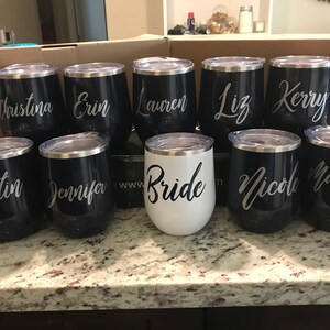 May include: Set of ten stainless steel wine tumblers with personalized names, including "Bride", "Kristin", "Jennifer", "Christina", "Erin", "Lauren", "Liz", "Kerry", "Nicole", and "Marissa".