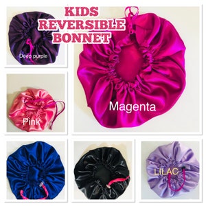 May include: Five reversible satin bonnets for kids in different colours: deep purple, pink, magenta, blue, and lilac. The bonnets have a gathered design and a drawstring closure.