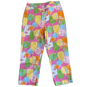 May include: Pink cropped pants with a colorful lantern print. The lanterns are in shades of yellow, orange, green, and blue.
