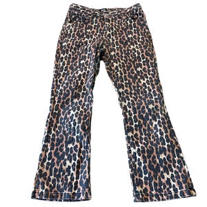 Op de afbeelding: Een paar bruine en zwarte jeans met luipaardprint en een wijde pijp.