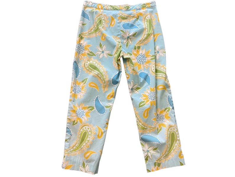 Puede incluir: Un pantal&oacute;n azul claro con estampado de paisley y flores. El estampado presenta colores amarillos, verdes y azules.