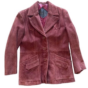 May include: A burgundy suede jacket with a button-up front and two flap pockets. The jacket has a classic, tailored fit.