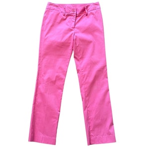 May include: A pair of pink straight-leg pants with a button closure and belt loops.