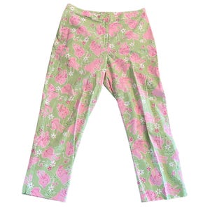 May include: Green pants with a pink and white floral pattern featuring cartoon pigs.