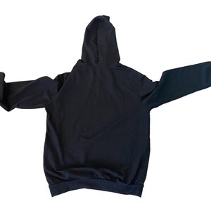 May include: A black hooded sweatshirt with long sleeves and a pouch pocket. The sweatshirt is made of a soft, comfortable fabric.