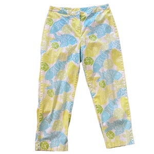 Puede incluir: Pantalones blancos con estampado de peces amarillos y azules.