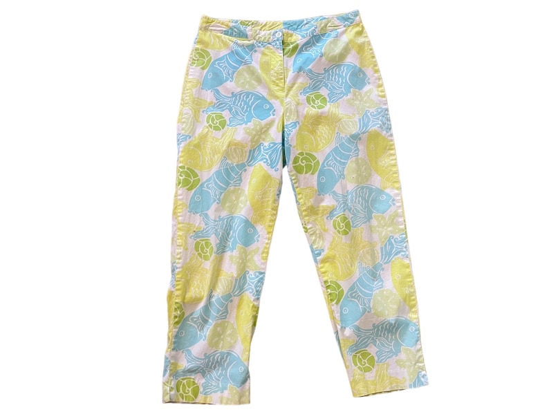 Puede incluir: Pantalones blancos con estampado de peces amarillos y azules.