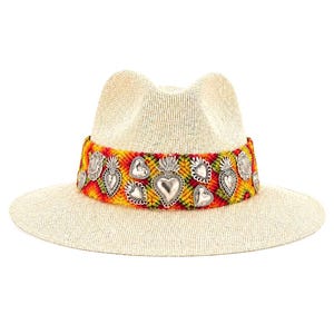 Handmade straw fedora hat for women with colorful Oaxacan knitted band and silver heart charms on white background