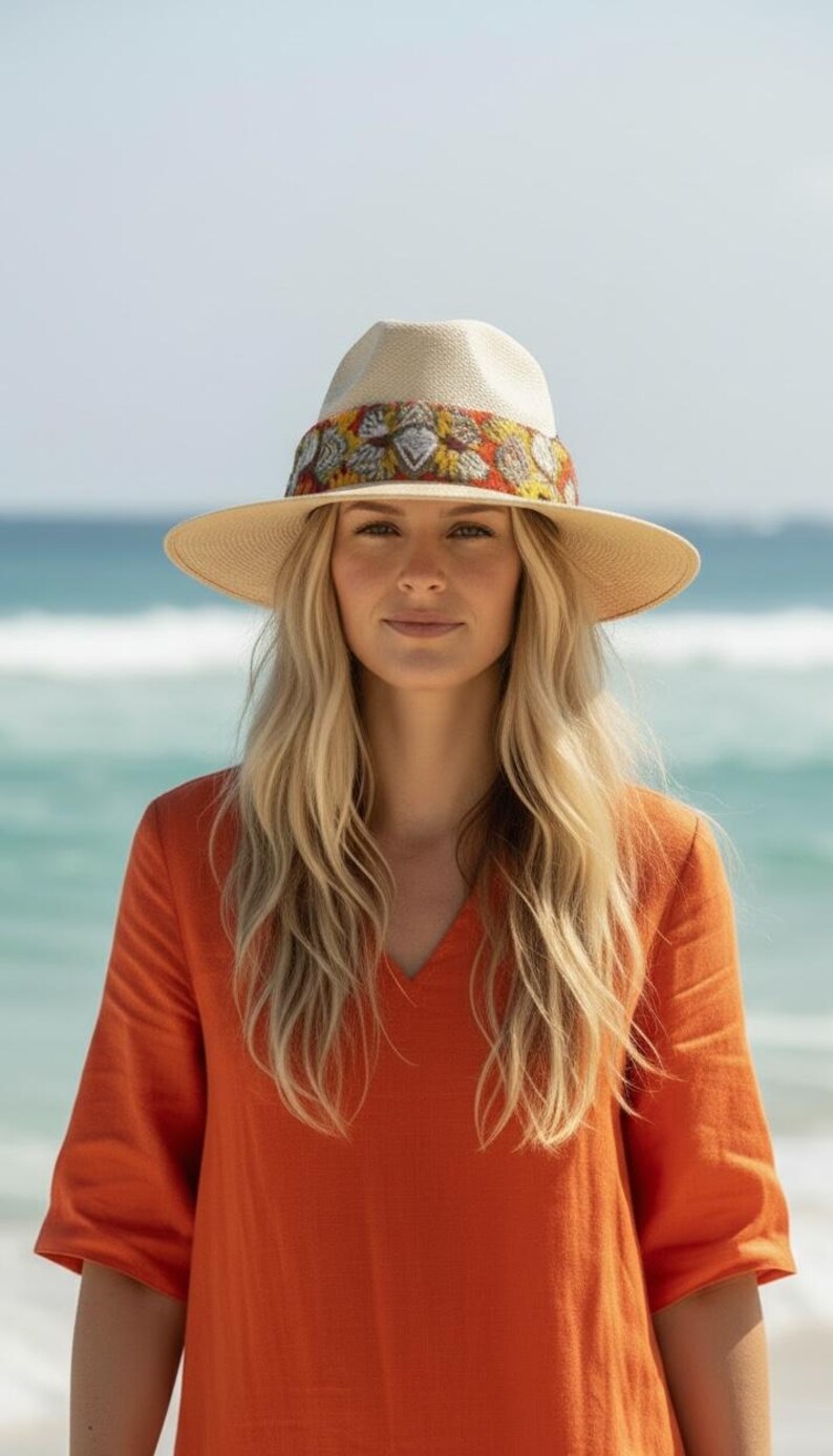 Model wearing handmade straw fedora hat with Oaxacan knitted band and silver heart charms for boho summer style