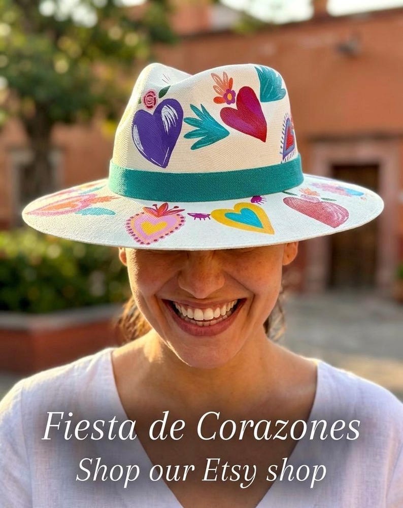 Model wearing colorful hand painted Mexican fedora hat with heart designs in lifestyle setting