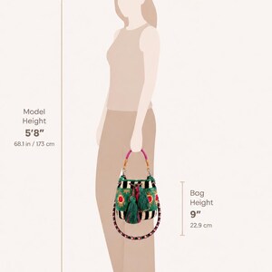 May include: A woven bucket bag featuring green, black, and white geometric patterns with a pink handle and dark green tassels. The bag has a height of 9 inches. A diagram shows a model height of 5'8" for scale, indicating the bag's size.