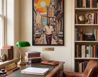 May include: A framed art print titled The Writer's Walk by James Baldwin, depicting a person walking down a city street with a stylized sun above. The print features warm orange, yellow, and brown tones, set against a wall with a brass nameplate.