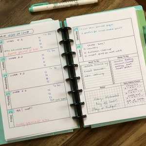 May include: A weekly planner with a turquoise cover and black rings. The planner is open to the week of October 22nd to 28th, 2018. The left page has a daily schedule for Monday through Friday, with handwritten entries for work, soccer games, and a to-do list. The right page has a schedule for Saturday and Sunday, with handwritten entries for chores, work to-do lists, and home to-do lists. The planner also includes a section for daily habits and chores, with checkboxes for vitamins, water, working out, and eating at home.
