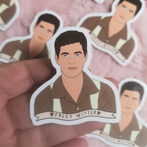 May include: A sticker featuring a cartoon illustration of a man with brown hair and a brown shirt with a white collar and suspenders. The sticker has a banner with the text "Pacey Witter" and a red heart on each side of the text.