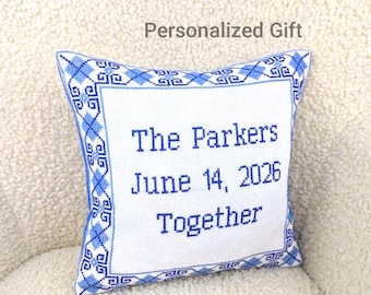 May include: A white square pillow with blue cross-stitch detailing and the words "The Parkers June 14, 2026 Together" in blue. The pillow has a blue patterned border and the text "Personalized Gift" above it.