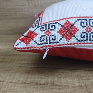 Detailed shot of the high-quality zipper closure on a square red black personalized decorative pillow cover, showing durable craftsmanship.