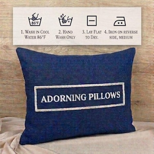 Care instruction infographic for the square red black personalized decorative pillow cover by Adorning Pillows: 1. Wash in cool water 86°F. 2. Hand wash only. 3. Lay flat to dry. 4. Iron on reverse side, medium.