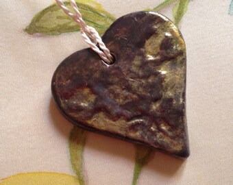 Medallion form aged bronze heart flowers and foliage motifs.