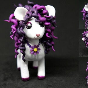 May include: A white figurine of a mouse-like creature with large ears and purple curly hair. It has a purple flower necklace and purple accents on its feet. The creature is standing on four legs.