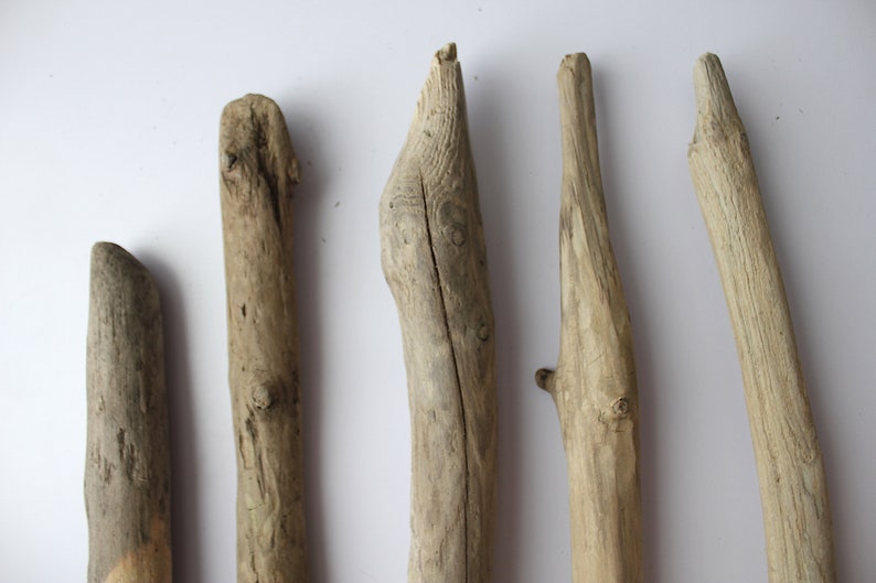 May include: Five pieces of driftwood of varying sizes and shapes, all with a natural, weathered gray finish.