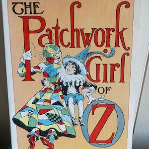 May include: A vintage book cover for "The Patchwork Girl of Oz" by L. Frank Baum. The cover features a colorful illustration of a patchwork figure and a child, with the title in large, stylized letters. The price tag shows $1.95.