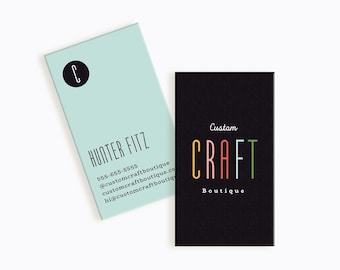 May include: Two business cards, one light blue with a black circle and the letter C, the text "HUNTER FITZ", a phone number, and an email address. The other card is black with the text "Custom CRAFT Boutique" in colourful letters.