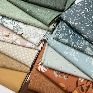 May include: A collection of folded fabric squares featuring a variety of patterns and solid colors including shades of green, brown, tan, and cream. The prints include botanical motifs, small geometric shapes, and textured surfaces in a layered arrangement.