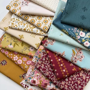 May include: A collection of folded fabric squares featuring a variety of patterns including floral prints, geometric shapes, and botanical motifs in a color palette of mustard yellow, deep burgundy, sage green, cream, and light blue.