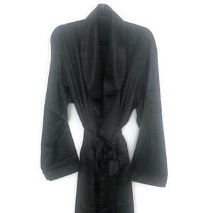 May include: A black satin robe with a shawl collar and a tie belt.