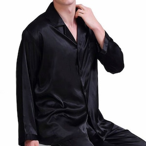 May include: A black satin long-sleeve shirt with a button-up front and a collared neckline.