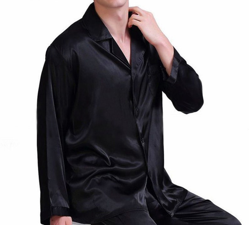 May include: A black satin long-sleeve shirt with a button-up front and a collared neckline.