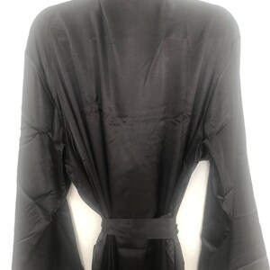May include: A black satin robe with long sleeves and a tie belt.