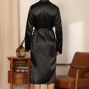 May include: A black satin robe with long sleeves and a tie belt.