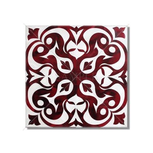 May include: A square tile with a white background and a burgundy floral pattern. The pattern is symmetrical and features intricate swirls and leaves.