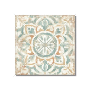 May include: A square canvas print with a distressed, vintage-inspired design. The pattern features a central floral motif in shades of blue, brown, and white, surrounded by a repeating geometric pattern.