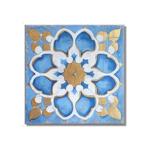 May include: A square canvas wall art featuring a blue and gold geometric design. The design is reminiscent of a traditional tile pattern with a central flower motif.