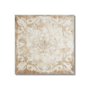 May include: Square decorative tile with a beige background and a white, ornate floral design. The design features a central floral motif surrounded by scrolling leaves and flourishes, creating a symmetrical pattern.