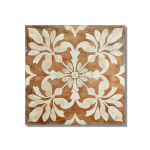 May include: Square decorative tile with a symmetrical floral design. The tile features a warm brown background with a white, stylized floral pattern. The design is centered and repeats in four directions, creating a balanced and elegant look.