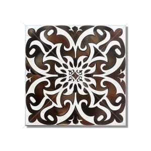 May include: A black and white square tile with a brown floral pattern. The tile has a symmetrical design with intricate details.