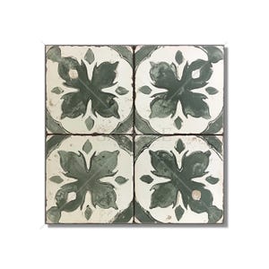 May include: Four square tiles with a distressed look. Each tile features a white background with a dark green floral design. The tiles are arranged in a square, showcasing the repeating pattern. The edges of the tiles have a slightly worn appearance.