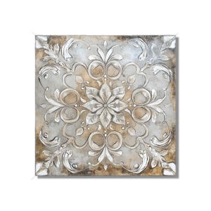 May include: Square wall art featuring a symmetrical floral and leaf design in white and silver against a neutral background. The artwork has a textured, raised relief appearance with a distressed, aged look.