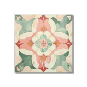 May include: Square decorative tile with a floral pattern. The design features a symmetrical arrangement of pink, green, and cream-colored shapes. The tile has a soft, painted appearance, with a subtle texture. The overall aesthetic is reminiscent of a vintage or bohemian style.