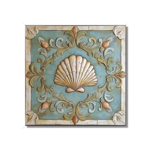 May include: A square wall decor with a raised seashell design in the center. The seashell is white with a gold sheen. The background is a light blue with a distressed finish. The border is a cream color with a raised floral design.